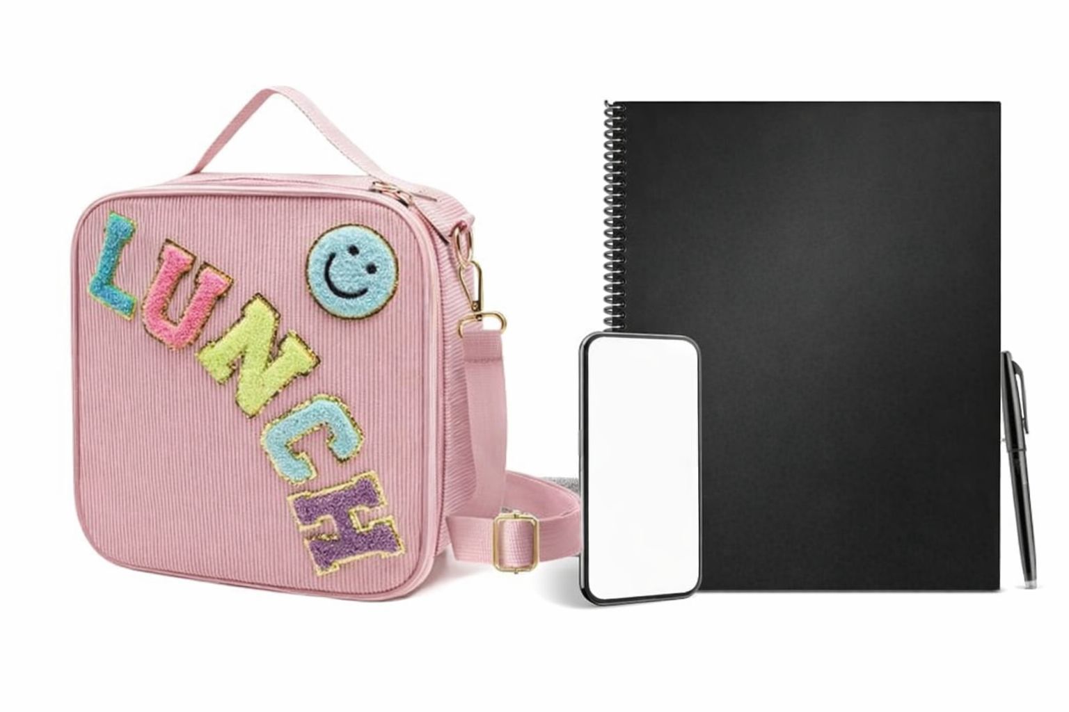 Rosa lunchväska med texten LUNCH bredvid ett svart block och mobil.